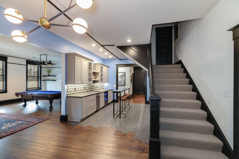 Modern basement in Bloomington, IL featuring a bar area, pool table, stylish lighting, and wood flooring with hex tile accents