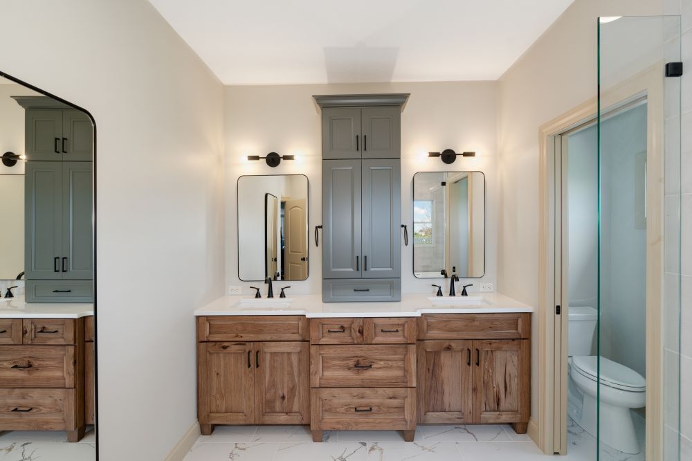 Bathroom in Bloomington Normal with rustic double vanity, gray center cabinet, black fixtures and sconces
