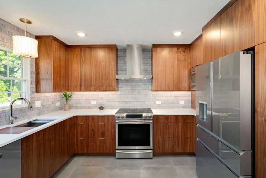 Modern kitchen with warm wood cabinets, stainless appliances and gray tile backsplash located in Bloomington, IL