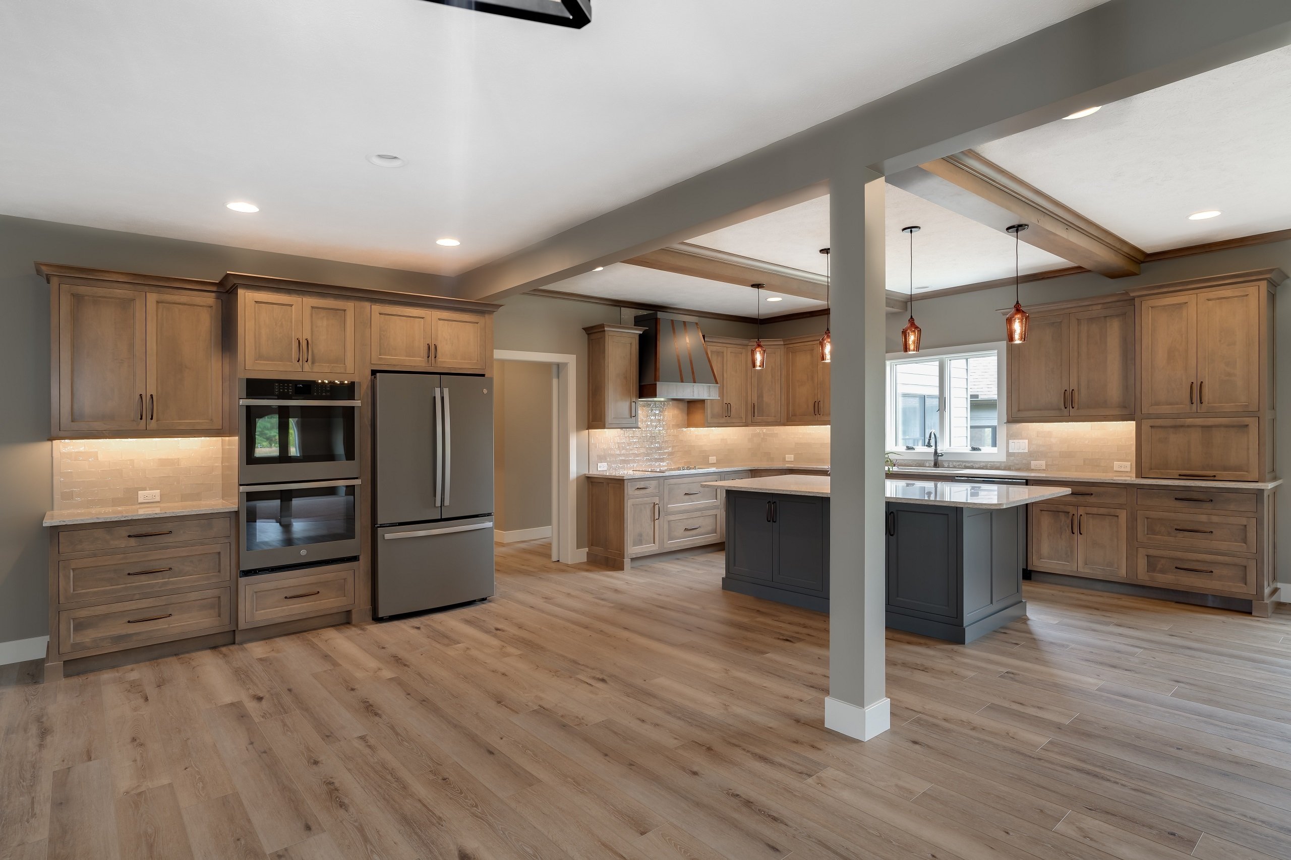 Open kitchen with wood cabinets, island, and warm lighting built by Landmark Construction and located in Illinois