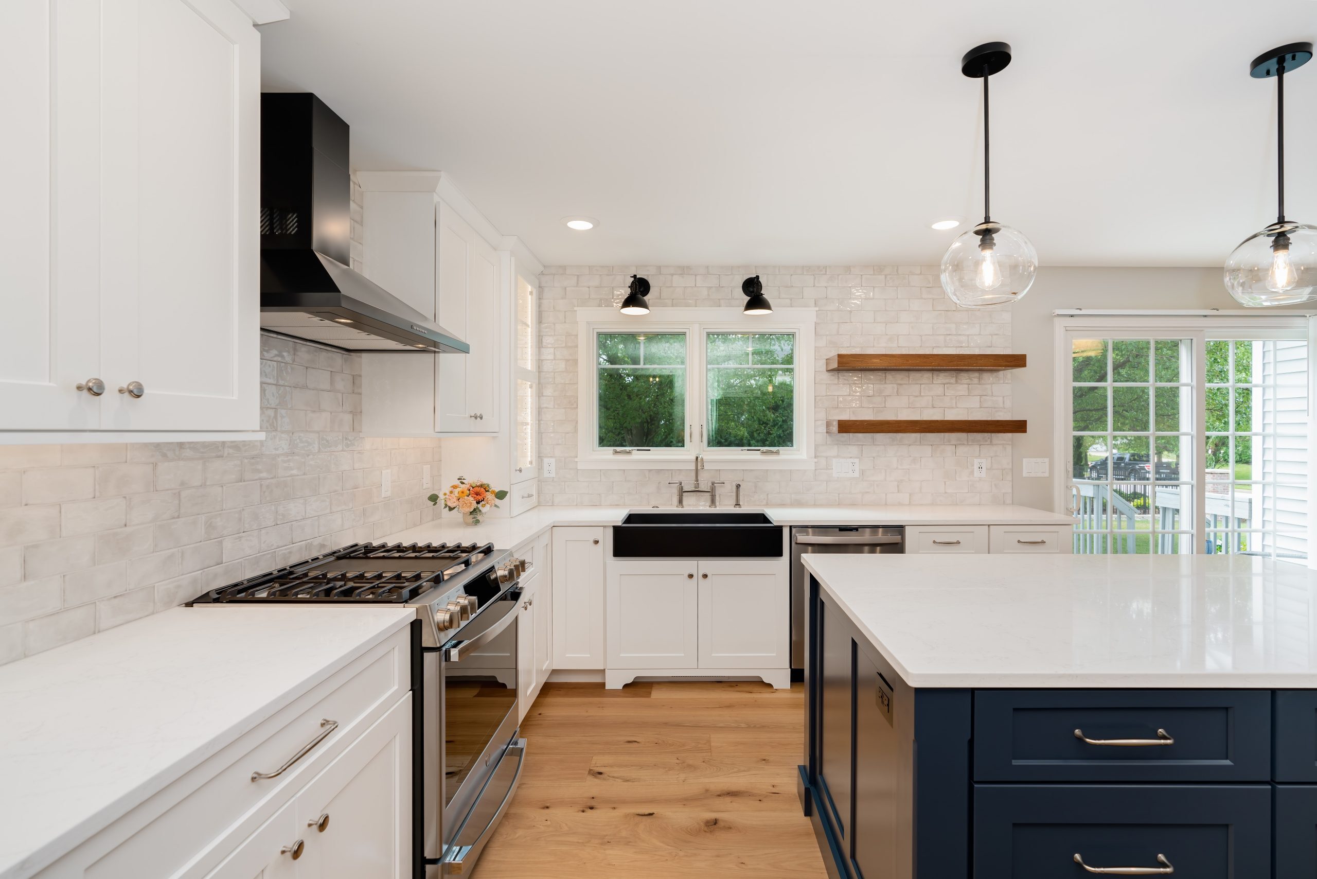 kitchen remodel with dark cabinetry island, granite countertops, and pendant lighting