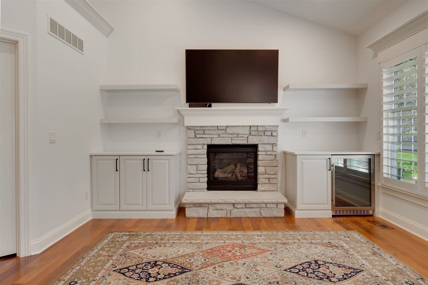 Living room with stone fireplace, built-ins, and hardwood floors, located in Illinois and built by Landmark Construction - 63 Stonbrook Ct -2