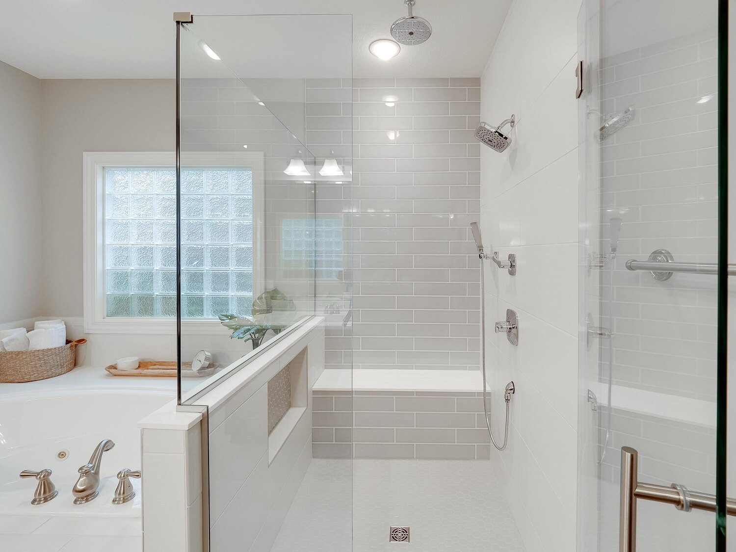 Modern bathroom with glass shower, gray tile, and soaking tub, built by Landmark Construction and located in Illinois