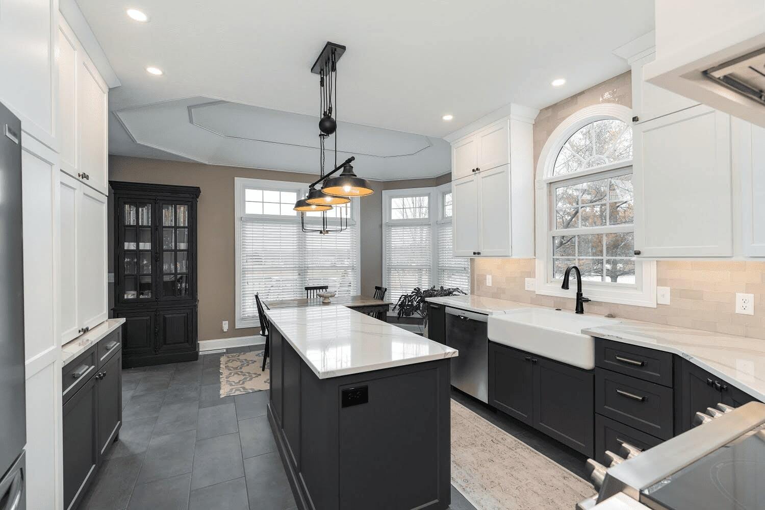 Modern kitchen with white uppers, dark lower cabinets, large island and farmhouse sink located in Bloomington, IL, built by Landmark Construction - unnamed-4-2