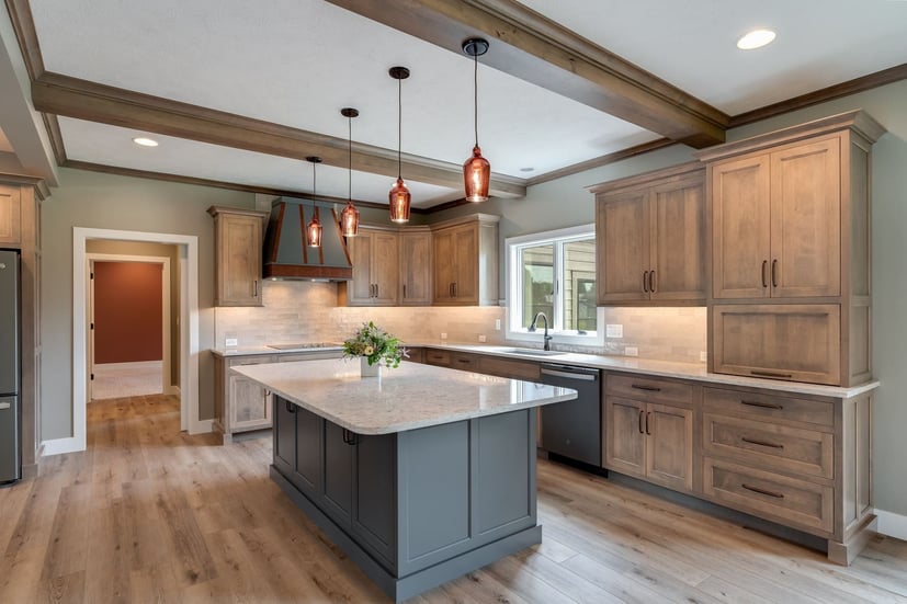 Spacious kitchen with wood cabinets, large island, and pendant lighting located in Bloomington, IL, built by Landmark Construction