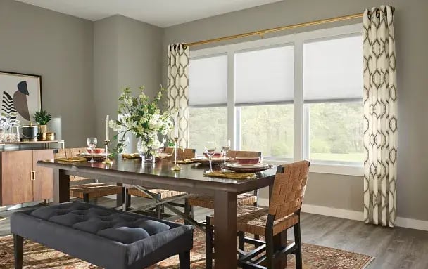 drapery with cellular shades in a dining area featuring green walls and wooden accents