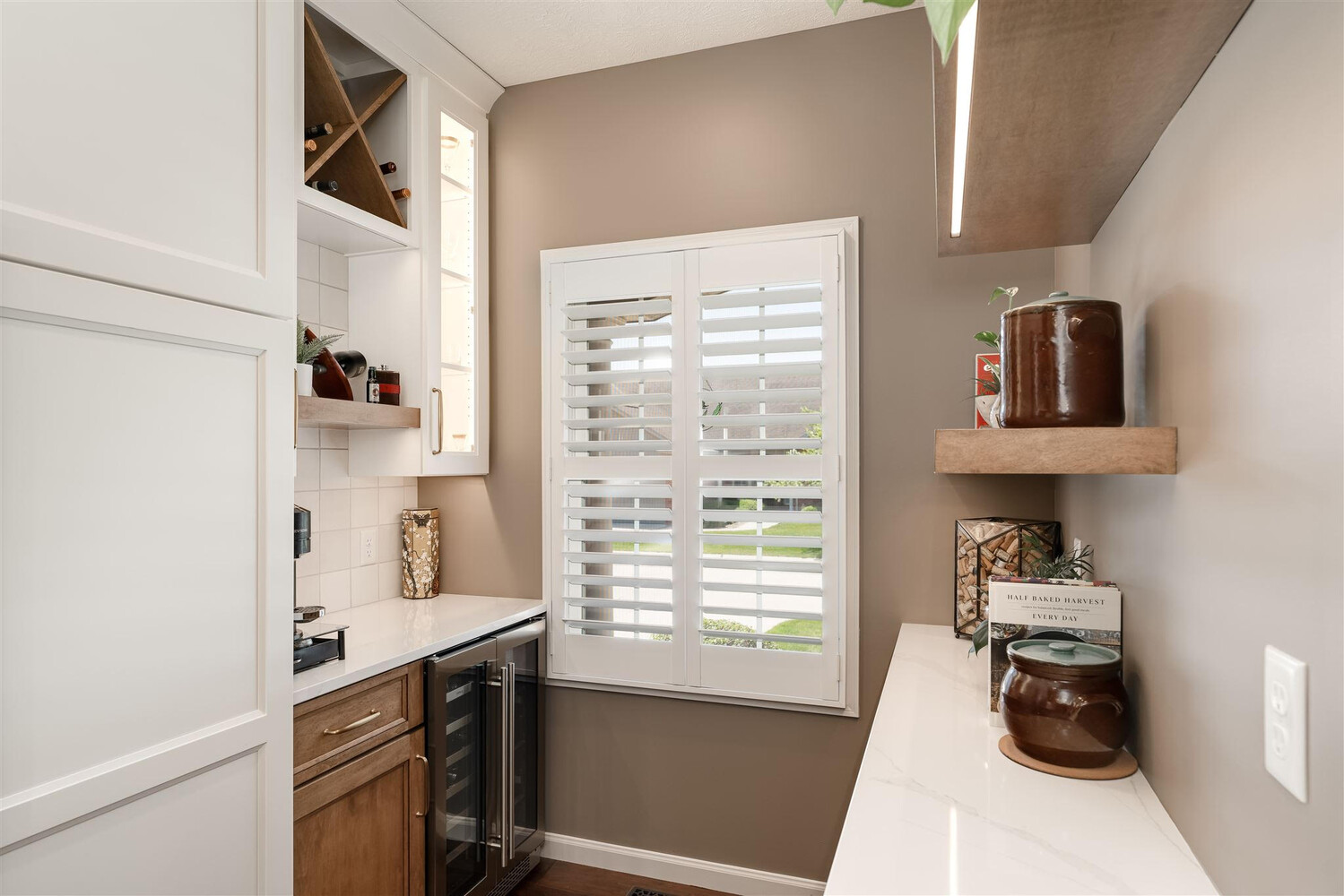 coffee bar with shutters, granite countertops and floating shelves 